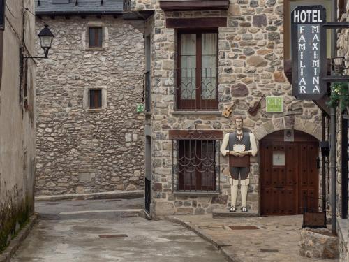 a statue of a man standing in front of a building at HOTEL FAMILIAR MAXIMINA in Sallent de Gállego