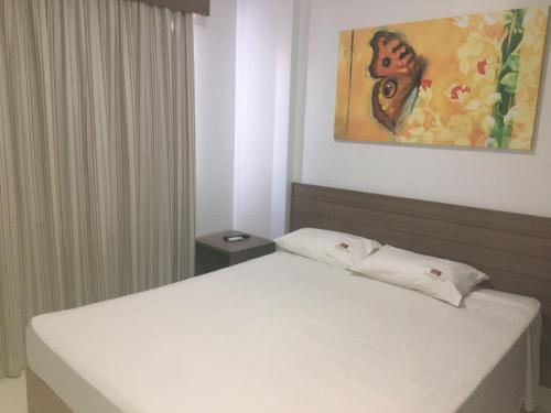 a bedroom with a bed and a painting on the wall at Veredas do Rio Quente - Flat 726 - Fantástico!!! in Rio Quente