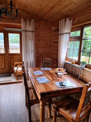 a dining room with a wooden table in a cabin at Unique Caravan with Outdoor Space Lodge in Ballantrae