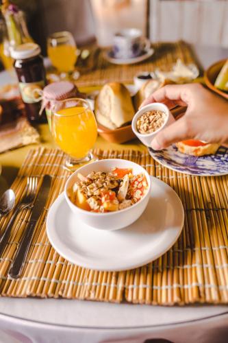 ein Tisch mit einer Schüssel Essen auf einem Teller in der Unterkunft Pousada Canto Verde in Serra do Cipo