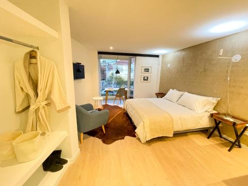 a bedroom with a bed and a bathroom at Lucitania Hotel Boutique in Bogotá