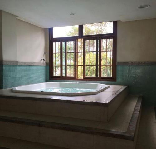 a large bath tub in a room with a window at Cond Vista Azul in Pedra Azul