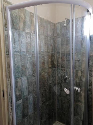 a shower with a glass door in a bathroom at Diyuyi Restaurant and Guest rooms Accommodation in Divundu