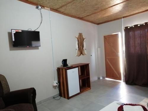 salon z telewizorem na ścianie i drzwiami w obiekcie Diyuyi Restaurant and Guest rooms Accommodation w mieście Divundu