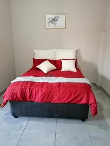 - un lit avec une couette rouge dans l'établissement Diyuyi Restaurant and Guest rooms Accommodation, à Divundu