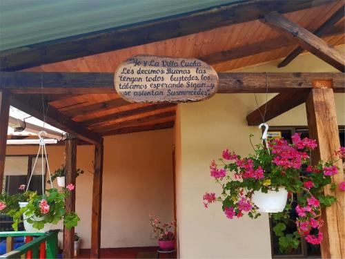 a building with flowers hanging from a wooden ceiling at VILLA CUCHA in Monguí