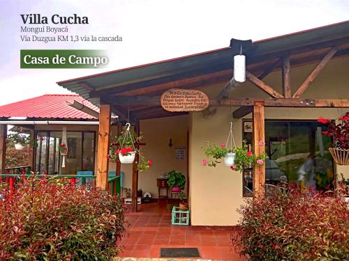 蒙圭的住宿－VILLA CUCHA，一座有盆栽植物的建筑,上面有标志