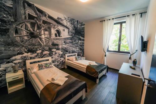 Duas camas num quarto com um mural de parede em Bagrina Suites em Belgrado