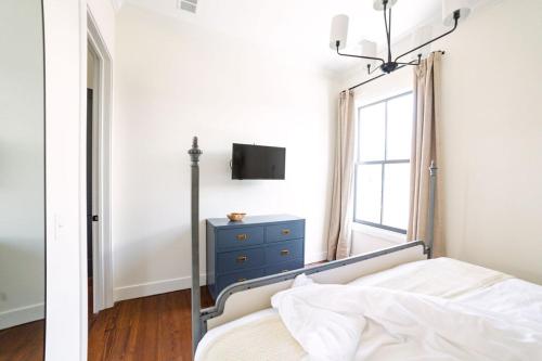 a bedroom with a bed with a blue dresser and a window at Guesthouse Charleston EAST 46 G in Charleston