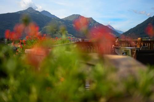 a view of a mountain with red flowers in the foreground at Sonnenburg Hotel in Ehrwald
