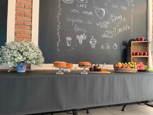 a table with a chalkboard with some food on it at Hotel St. Daniel in Guarulhos