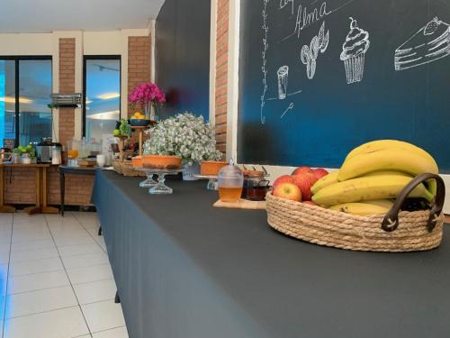 a counter with baskets of bananas and apples on it at Hotel St. Daniel in Guarulhos