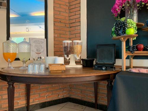 a wooden table with drinks and glasses on it at Hotel St. Daniel in Guarulhos