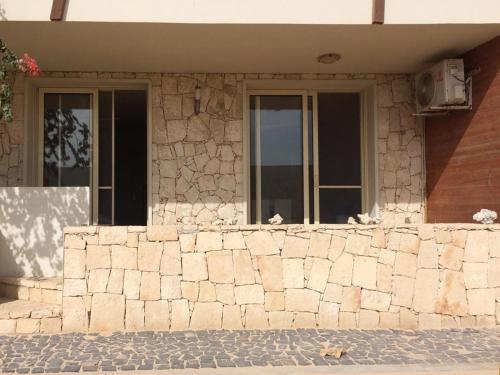 a building with two birds sitting on a stone wall at KatlantiK Ca Madeira Deluxe in Sal Rei