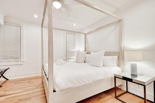 a white bedroom with a large bed and a table at Guesthouse Charleston SOUTH 105 A and B in Charleston