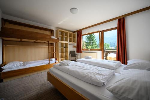 een grote slaapkamer met 2 bedden en een raam bij Sonnenburg Hotel in Ehrwald