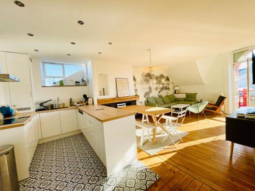 eine Küche und ein Wohnzimmer mit einem Tisch und einer Couch in der Unterkunft Appartement avec balcon au coeur de la Baule in La Baule