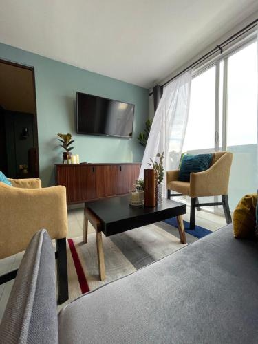 a living room with a couch and a tv on a wall at Departamento *MUNDO VIAJERO* Guadalajara in Guadalajara