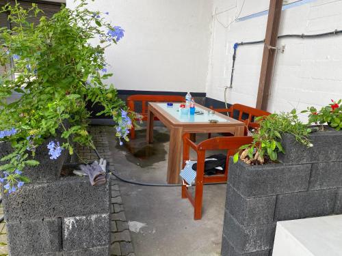 a small table and chairs in a patio with flowers at Pension Neon in Mannheim
