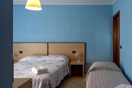 1 dormitorio con 2 camas y pared azul en B&b Serena, en Roncofreddo