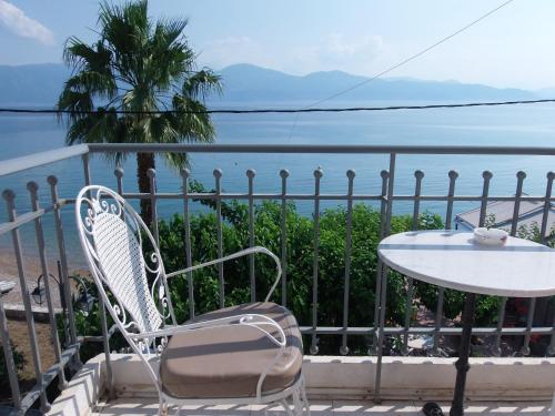 a table and a chair on a balcony with the ocean at Plaz Hotel in Selianitika
