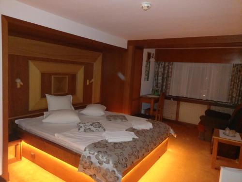 a bedroom with a large bed with white pillows at Villa Elitte Predeal in Predeal