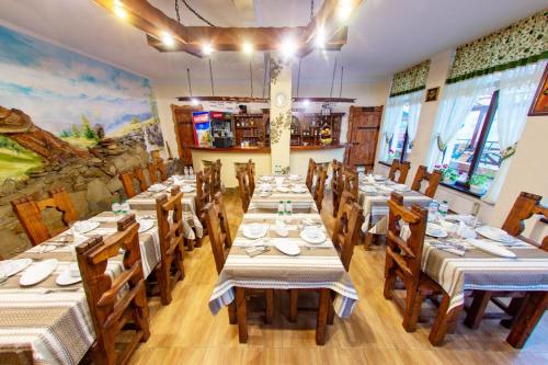 a dining room with long tables and wooden chairs at Georgiy in Oryavchyk