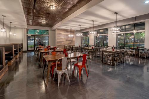 a restaurant with wooden tables and chairs and windows at Holiday Inn & Suites Wausau-Rothschild by IHG in Rothschild