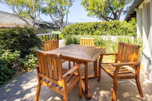 a wooden table and chairs on a patio at The Quail Lodge in Carmel