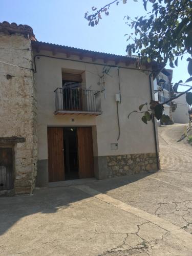 a white building with a balcony and a door at Antigua Casa Pepo y Casa Marieta in Herbés