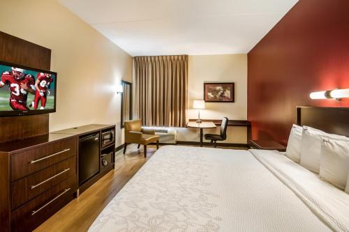 a hotel room with a large bed and a television at Red Roof Inn PLUS+ South Deerfield - Amherst in South Deerfield
