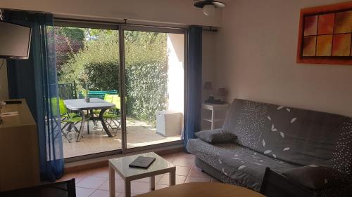 un salon avec un canapé et une porte coulissante en verre dans l'établissement Ker MARIE JO, à La Baule