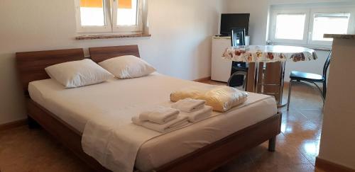 sypialnia z łóżkiem z ręcznikami w obiekcie Apartmani Citrus Novigrad w mieście Filipac