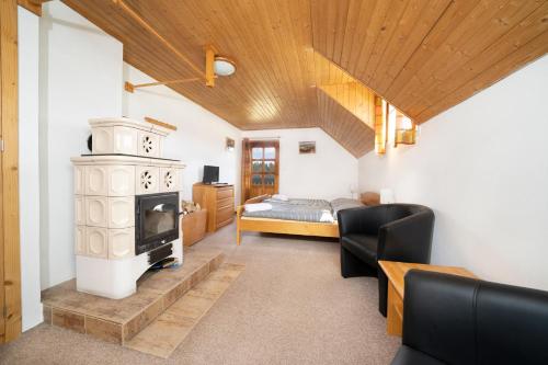 a living room with a fireplace and a bed at Penzion U Churáňů in Stachy