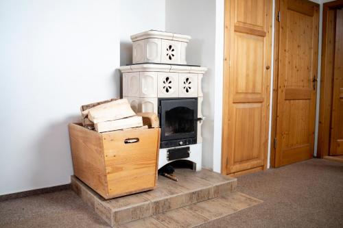 a fireplace in a room with a box and a wooden door at Penzion U Churáňů in Stachy