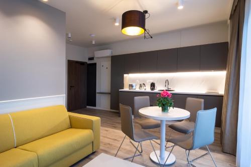 a living room with a yellow couch and a table at Aparthotel NOX in Cluj-Napoca