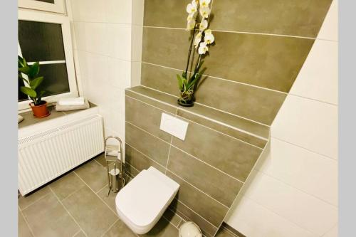 a bathroom with a toilet and a vase with flowers at FeWo Seenest #Netflix #Seenähe #Einkaufen von Harztraveler in Goslar