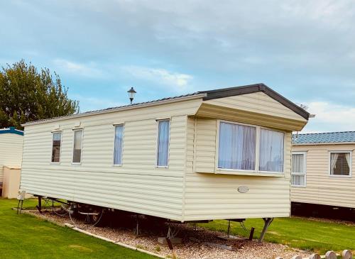 a large white house on display in a yard at L38 Caravan Mablethorpe With ramp and gated decking in Mablethorpe