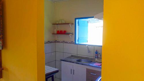 uma pequena cozinha com um lavatório e uma janela em Fortuna Casas de Campo em Socorro