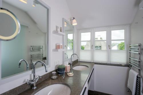 a bathroom with two sinks and a large mirror at Benen-Diken-Hof in Keitum