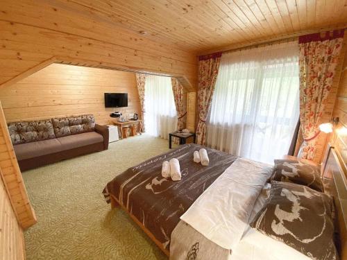 ein Schlafzimmer mit einem Bett und einem Sofa in einem Zimmer in der Unterkunft Georgiy in Oryavchyk