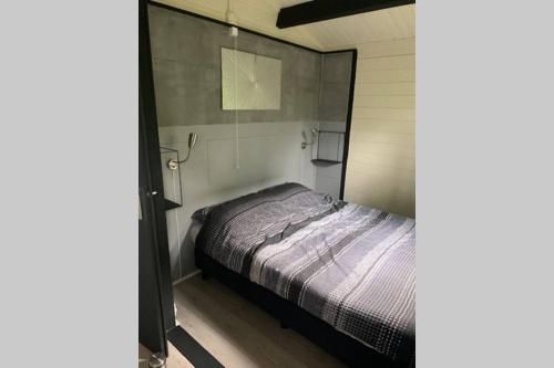 een slaapkamer met een bed in een kleine kamer bij Sfeervolle blokhut op de Veluwe op recreatiepark Topparken in Beekbergen met vrije tuin en eigen parkeerplaats in Beekbergen