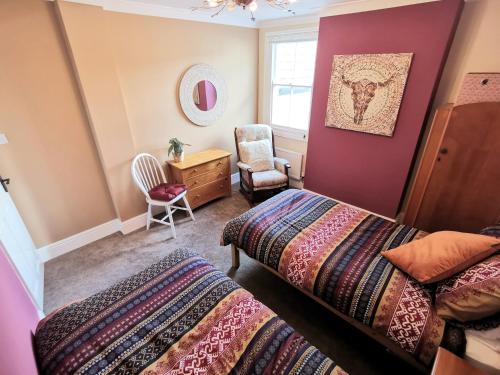 1 dormitorio con 2 camas, escritorio y silla en The Bridge Cottage en Llanrwst
