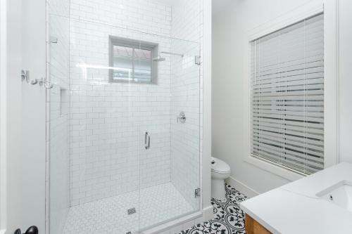 Un baño blanco con ducha y WC. en Guesthouse Charleston WEST 242 B, en Charleston