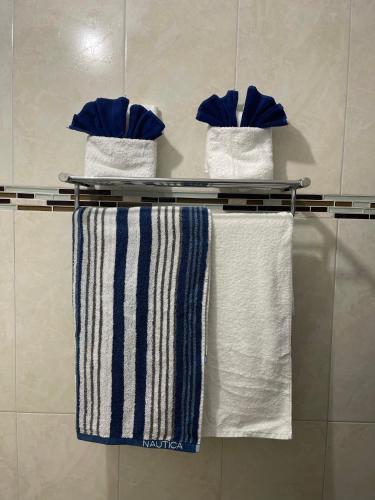 tre asciugamani su un portasciugamani in un bagno di Jamrock Suites a Kingston