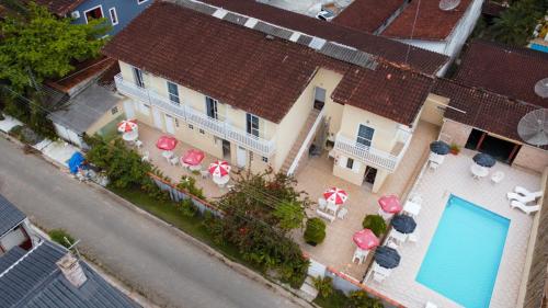 - une vue sur une maison dotée de parasols et d'une piscine dans l'établissement Pousada Vila Real Juquehy, à Juqueí