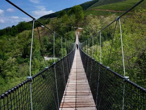 a person standing on a suspension bridge at Palacio de Yrisarri by IrriSarri Land in Igantzi