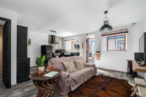 a living room with a couch and a table at Casa Celeiro in Estômbar