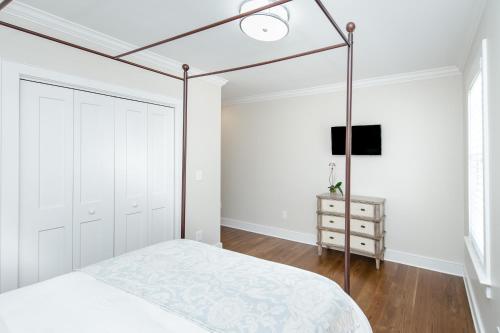 um quarto branco com uma cama de dossel e uma cómoda em Guesthouse Charleston WEST 64 em Charleston