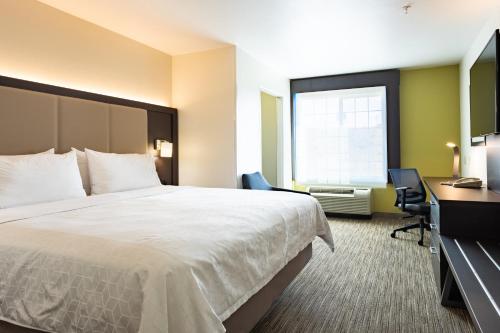 a hotel room with a bed and a desk and a window at Holiday Inn Express Hotel & Suites Evanston by IHG in Evanston